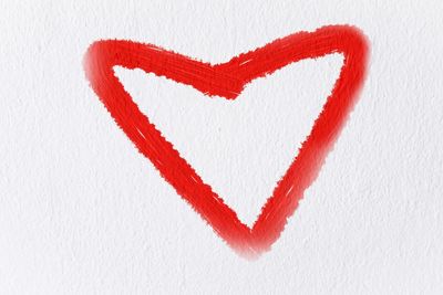 Close-up of red heart shape on white background