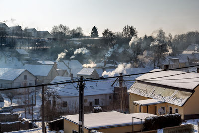 Houses in city against sky during winter