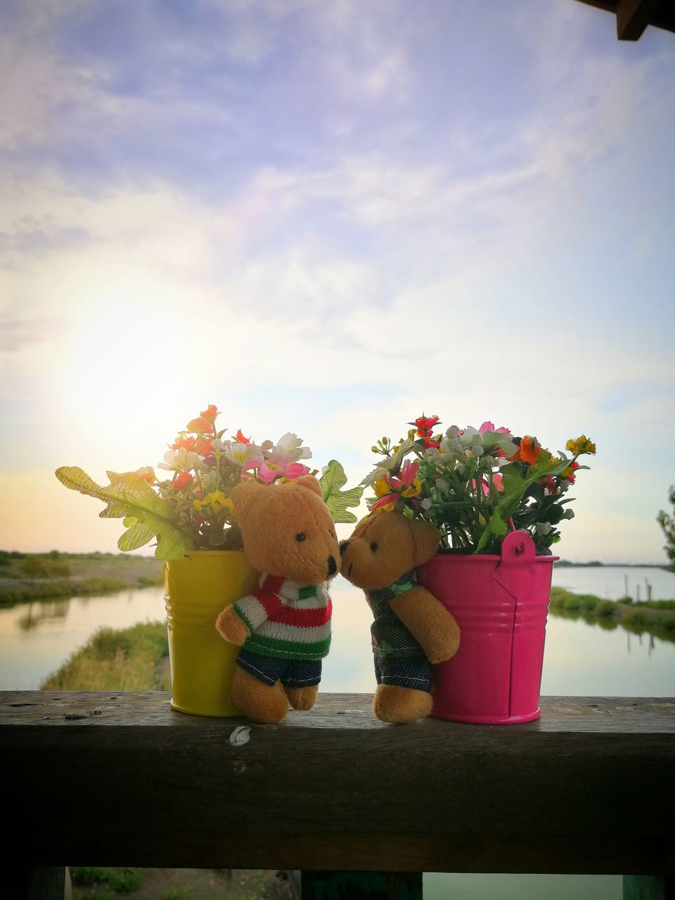 CLOSE-UP OF RED TOY IN CONTAINER AGAINST PLANTS