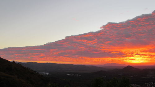 Scenic view of silhouette mountains against orange sky