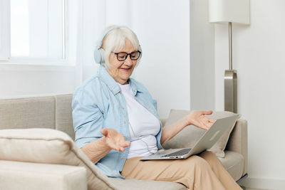 Portrait of young woman using laptop at home