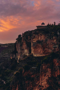 Rock formations on cliff against sky during sunset