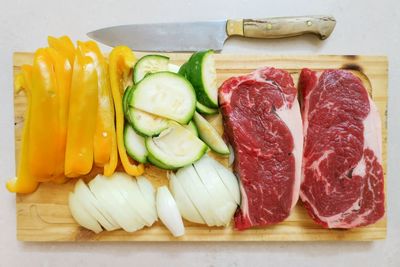 Directly above view of raw food on cutting board by knife