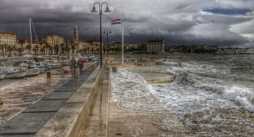 View of harbor against cloudy sky