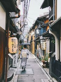 Rear view of street amidst buildings in city