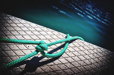 Close-up of rope on retaining wall by river