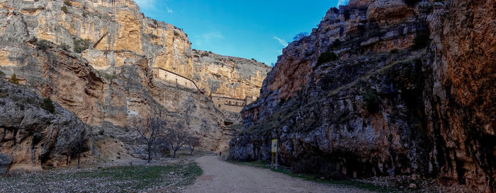 Road amidst rocky mountains against sky