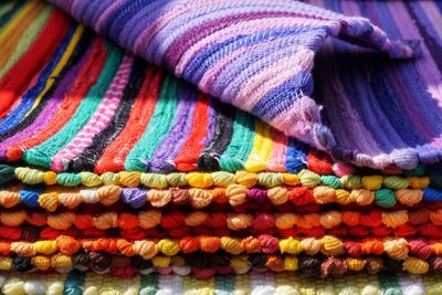 Close-up of stacked colorful doormats for sale at market