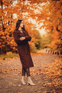 Portrait of a young woman in a brown coat in autumn