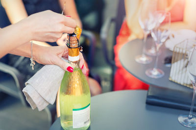 Close-up of hand holding drink served on table