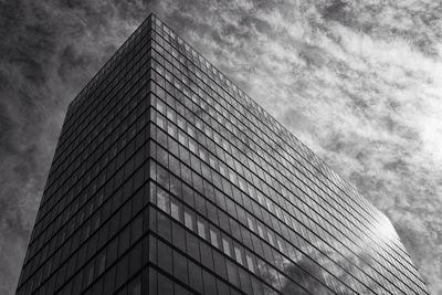 Low angle view of modern building against cloudy sky