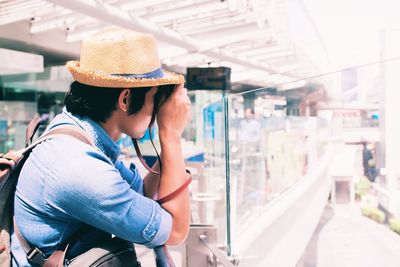 Side view of woman wearing hat in store