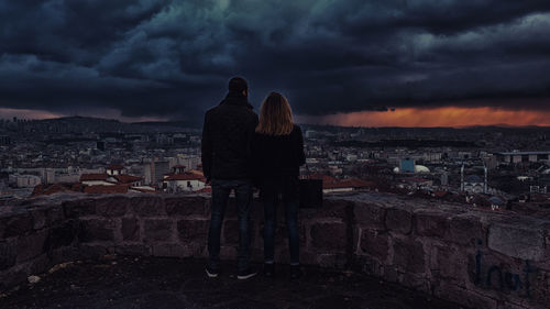 Cityscape against cloudy sky at sunset