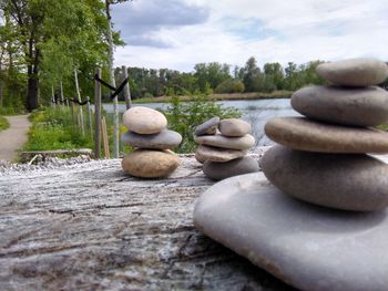 Close-up of stack of pebbles on rocks against sky