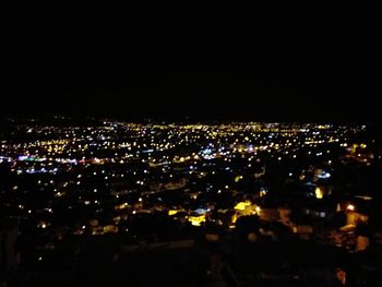 High angle view of illuminated city against clear sky at night