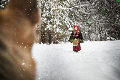 Rear view of man standing on snow covered field