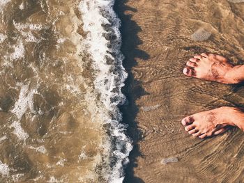 Low section of man relaxing on beach