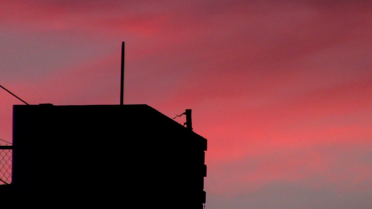 LOW ANGLE VIEW OF SILHOUETTE BUILDINGS AGAINST ORANGE SKY