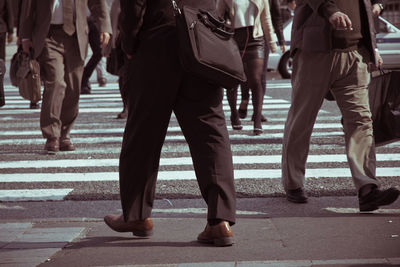 Low section of business people walking on road