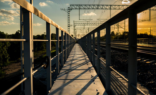 Footbridge against sky in city