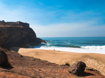 Scenic view of beach against blue sky