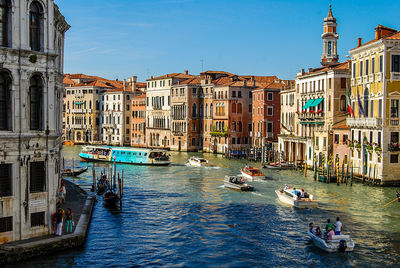 Boats in canal against buildings