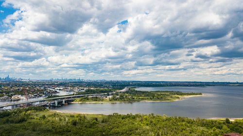 Bridge over river in city against sky