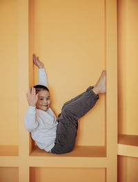 Boy enjoys his personal hideaway in orange cubby. inviting atmosphee, perfect imaginative play