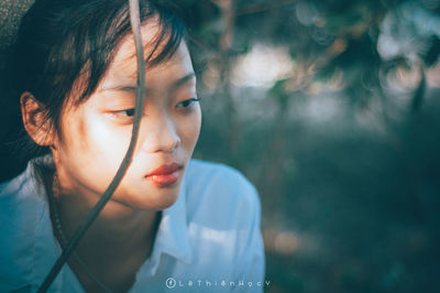 Close-up portrait of a young woman looking away