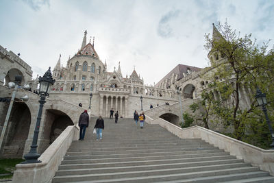 Low angle view of people outside building against sky