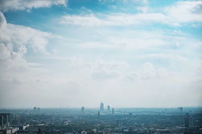 View of cityscape against cloudy sky