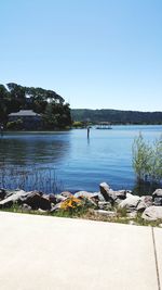 Scenic view of lake against clear blue sky