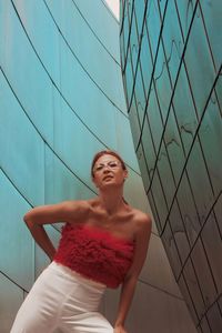 Full length of young woman  stands near a mirrored wall