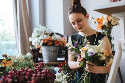 Woman standing by potted plant