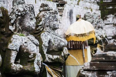 Statue by temple against rock