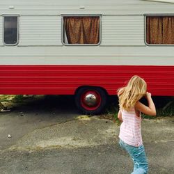 Girl walking against bus parked on street