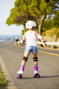 Rear view of woman with umbrella on road