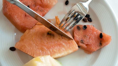 Close-up of fork on watermelon in plate