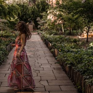 Rear view of woman walking on footpath