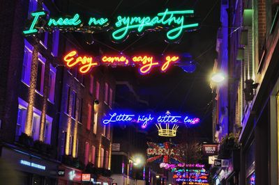 Low angle view of illuminated text on building at night