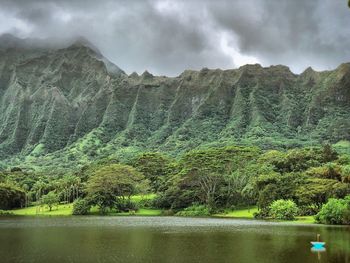 Scenic view of lake by mountains against sky