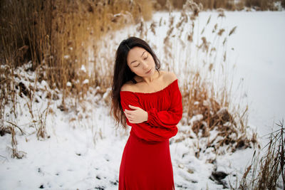 Asian woman in red long dress on snow