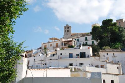 Low angle view of buildings against cloudy sky