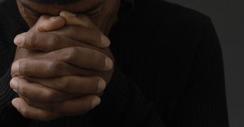 Midsection of man gesturing against wall