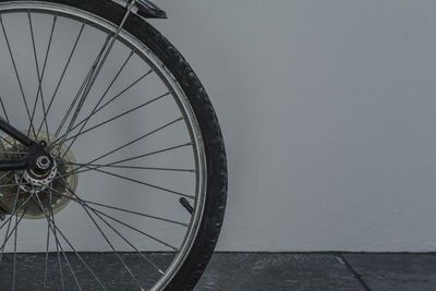 Close-up of bicycle wheel against wall