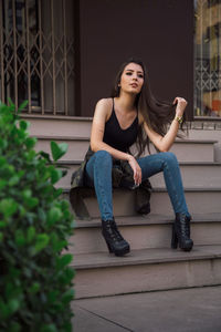 Beautiful young woman sitting on staircase