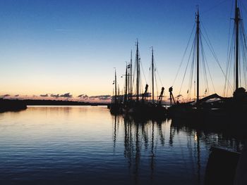 Sailboats moored at sunset