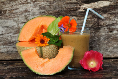 Close-up of cantaloupe with juice on wooden table