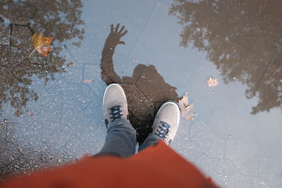 Low section of man standing on puddle