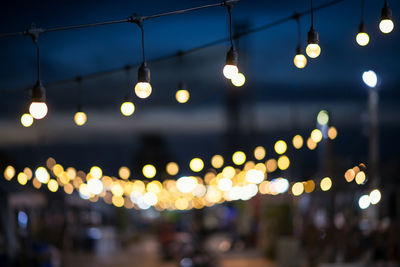 Defocused image of illuminated lights on street at night